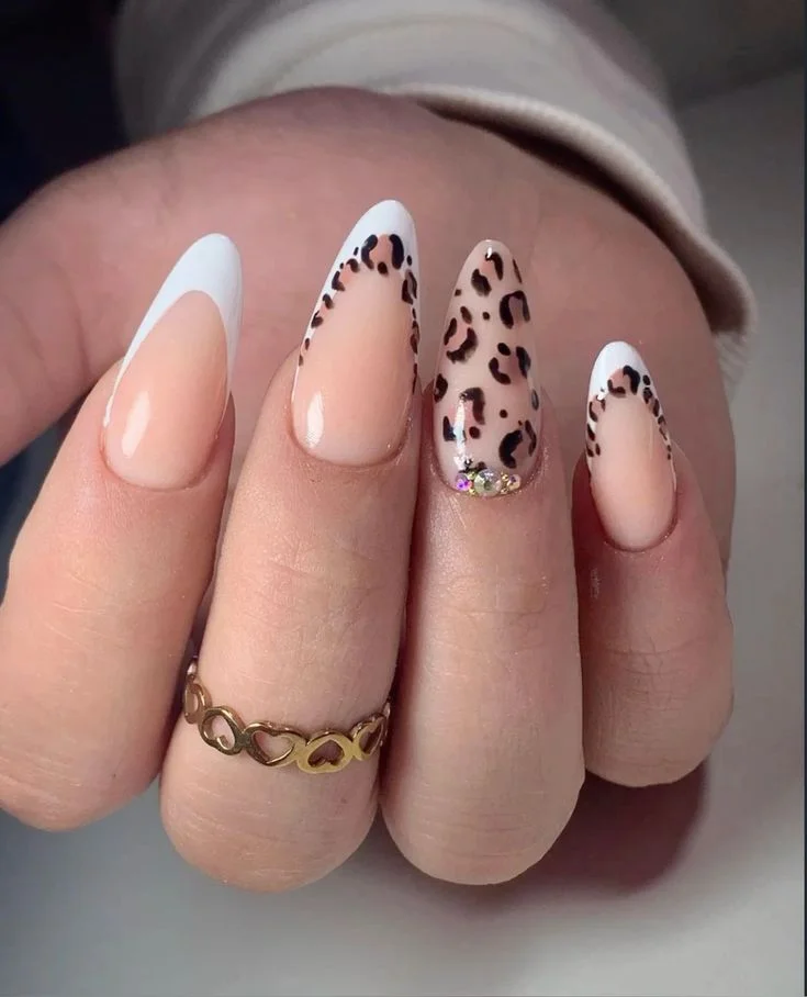 Unhas com estampa animal print de onça, com manchas em tons de marrom, preto e dourado, proporcionando um visual sofisticado e moderno.