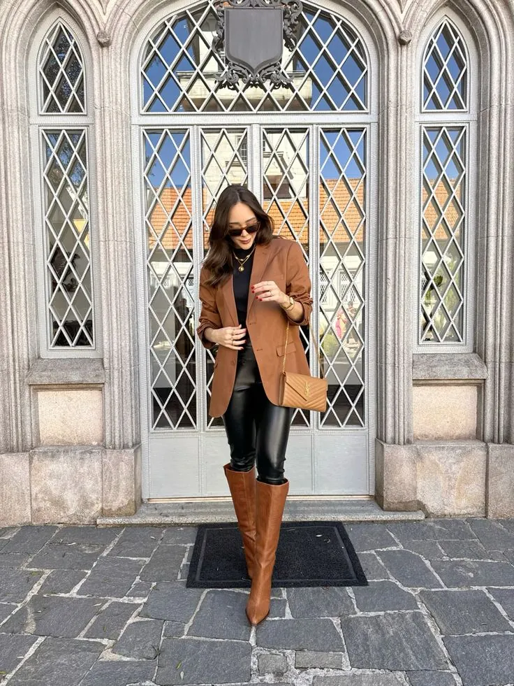 Mulher com blazer marrom, legging preta e bota de cano alto