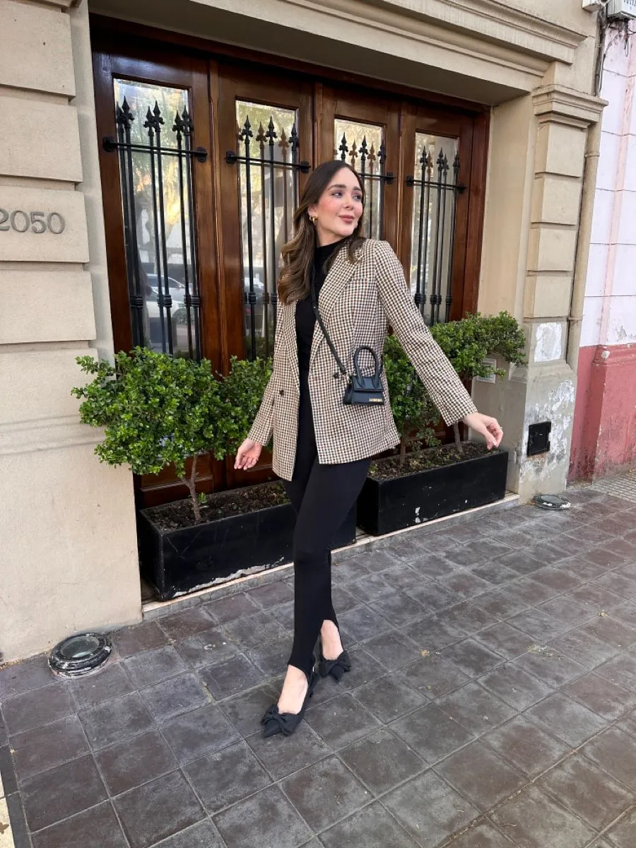 Mulher usando calça legging preta com blazer oversized e bolsa preta