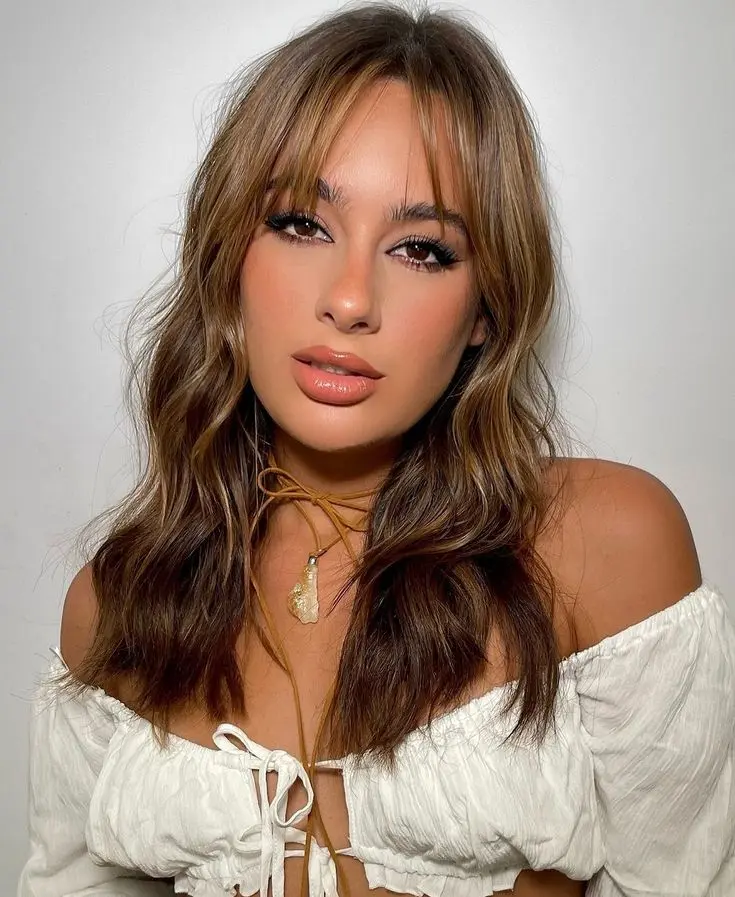 Mulher com franja fina e sutil com um visual sofisticado.