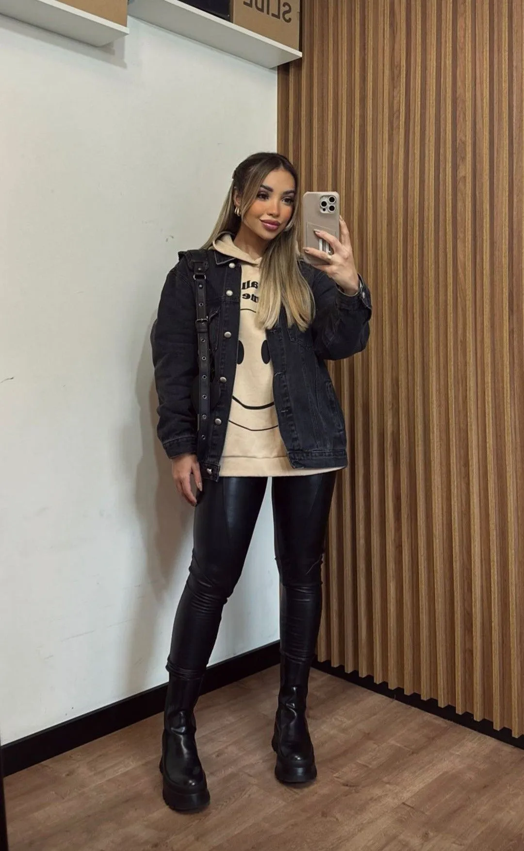 Mulher usando calça legging preta, jaqueta jeans e botas pretas
