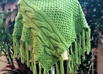 Poncho verde com franjas, tendência de moda para 2025, sobre manequim