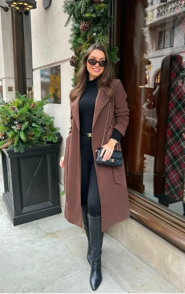  Mulher com trench coat marrom, bota de bico fino e legging preta