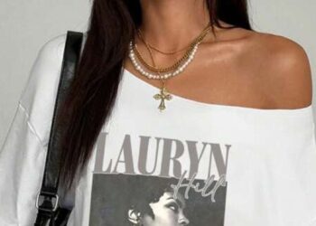 Mulher usando camiseta branca com estampa de Lauryn Hill e ombro caído, estilo anos 2010.