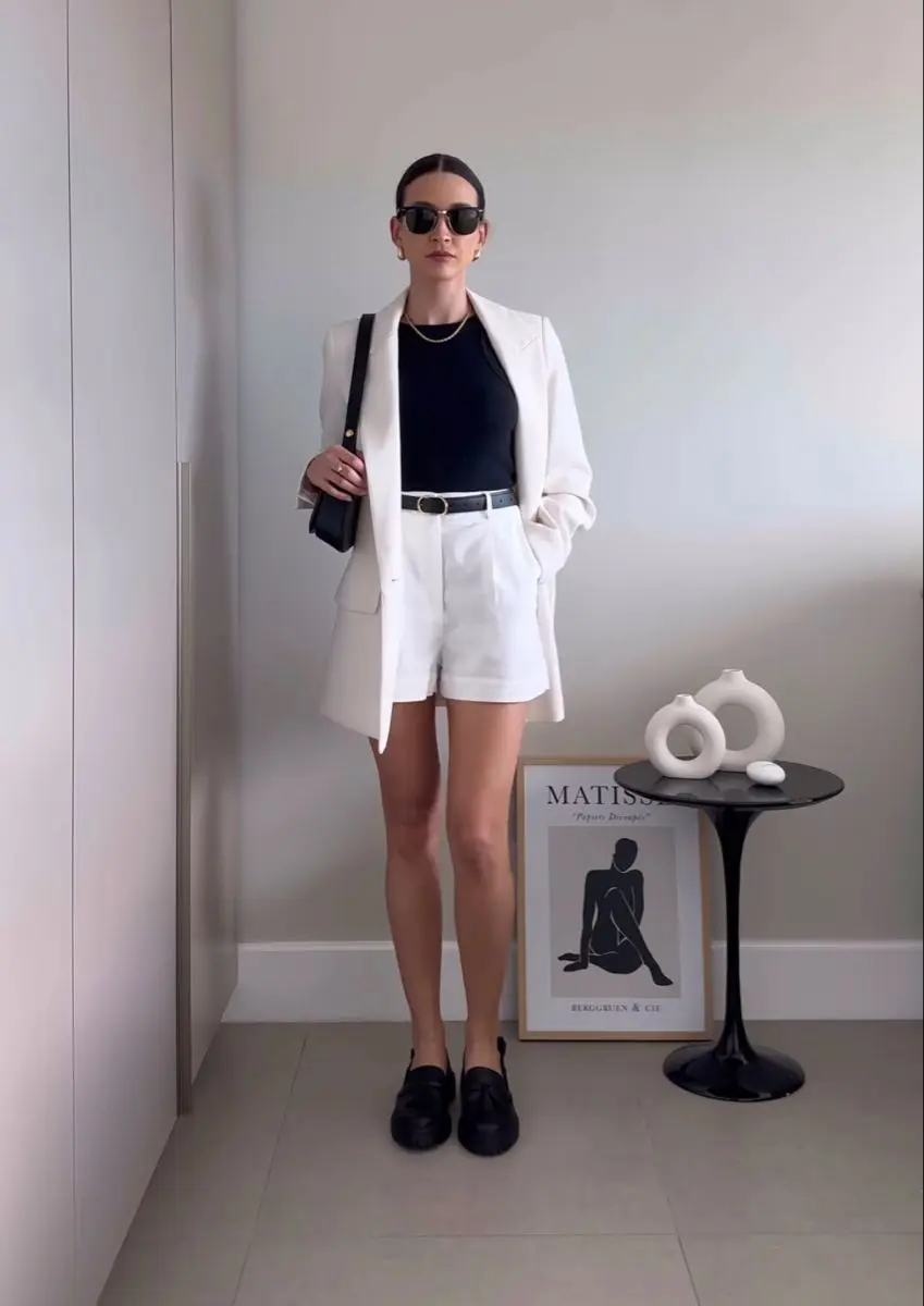 Imagem de um look moderno com blazer leve, shorts amplos e regata, criando um visual casual e elegante.