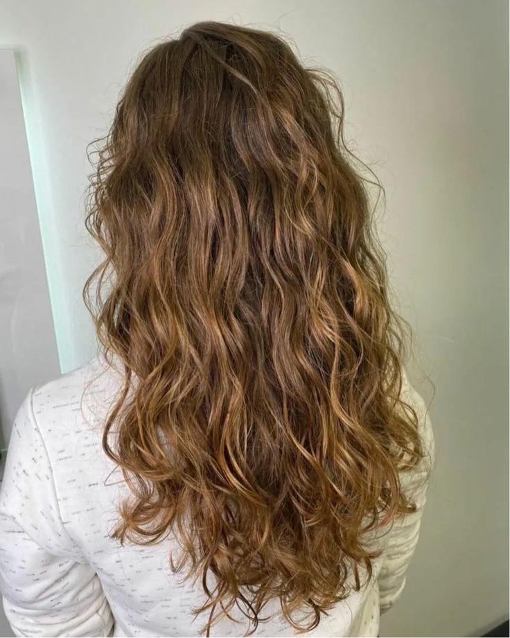 Mulher de costas exibindo o cabelo castanho claro com ondas leves, evidenciando o tipo de curvatura do cabelo.
