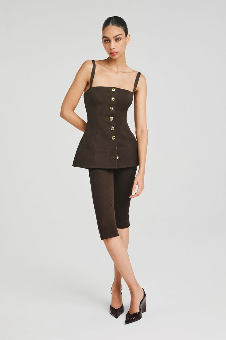 Modelo vestindo uma calça corsário e uma blusa de alcinha marrom, para um visual elegante e moderno.