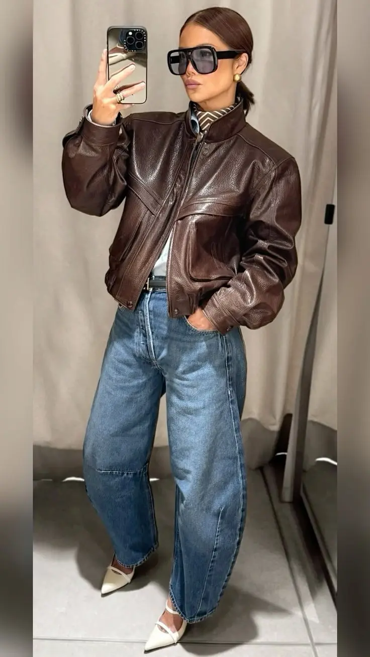 Mulher estilosa usando jaqueta marrom com jeans largo em look urbano casual-chique