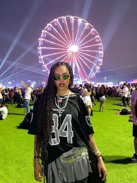 "Look metalizado com camiseta de futebol americano no festival The Town 2025, com uma roda gigante iluminada ao fundo.