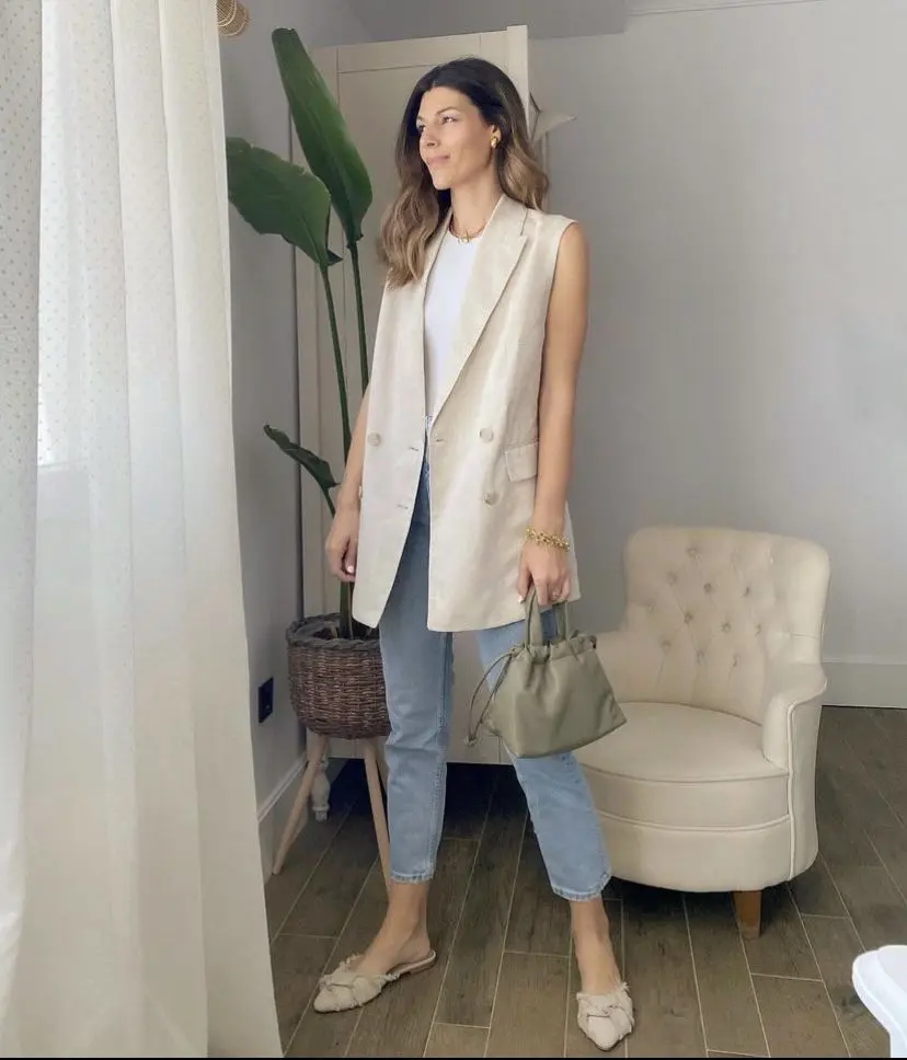 Look de quinta-feira com camadas: colete de alfaiataria sobre camiseta básica, calça jeans e combinação de texturas