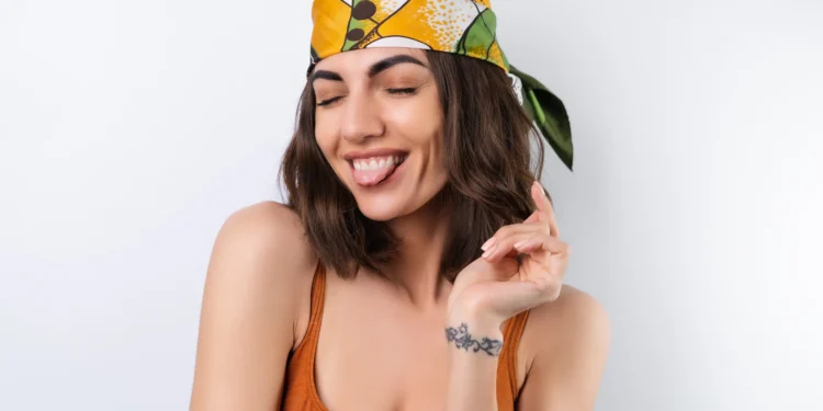 Mulher sorrindo com lenço colorido na cabeça, tendência para a primavera 2025.