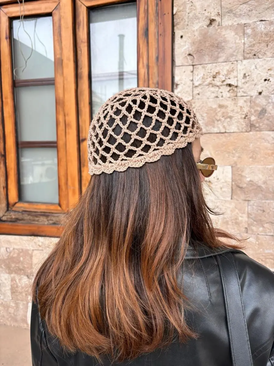 Touca de crochê estilosa com ponto aberto, usada com cabelo solto em estilo urbano.