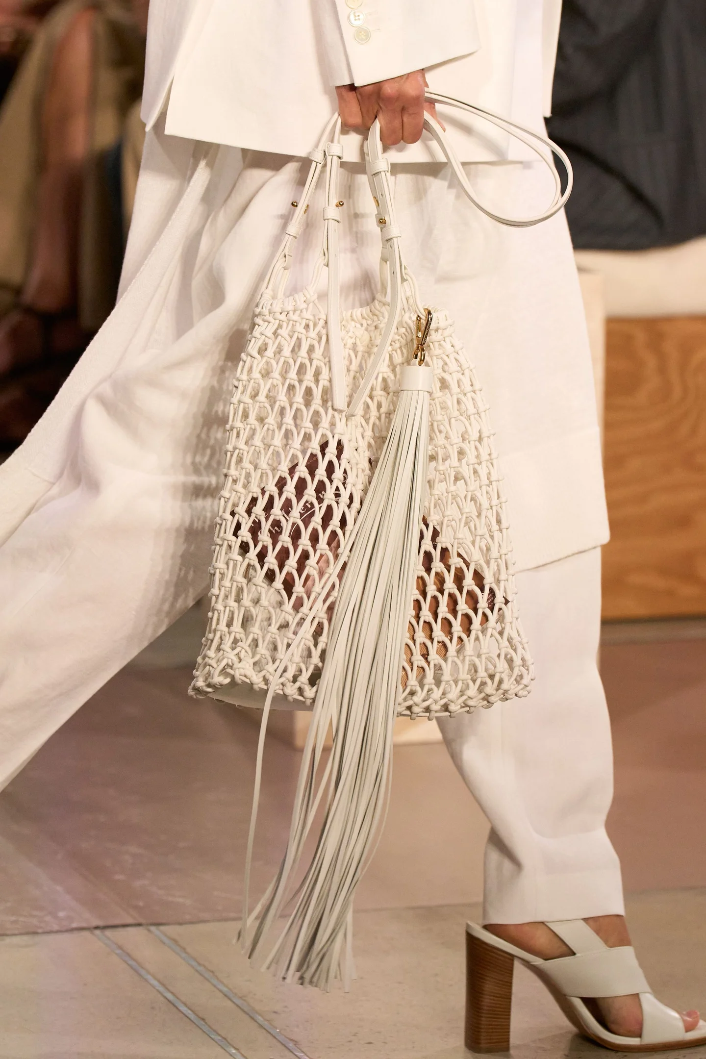 Bolsa de trama aberta e artesanal com franja, destacando a tendência de transparência na New York Fashion Week SS26.