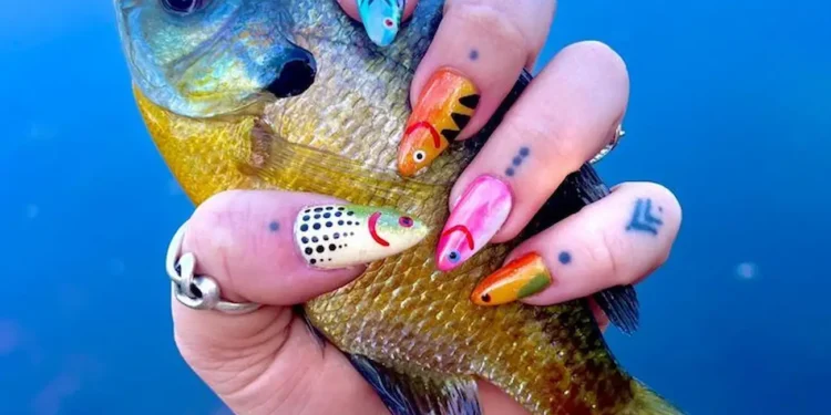 Tendência em alta: unhas de peixe são o novo hit fashion que você precisa conhecer 1 Unhas de peixe em destaque com uma mão segurando um peixe, com design de unhas criativas em formato de peixes coloridos.