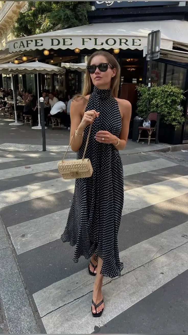 Mulher usando vestido longo preto de bolinhas.