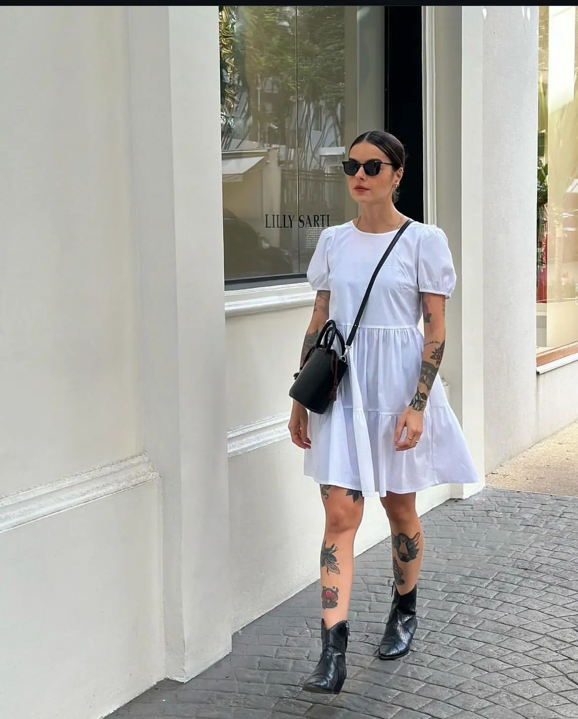 Pessoa usando bota e vestido elegante, em estilo casual e moderno.