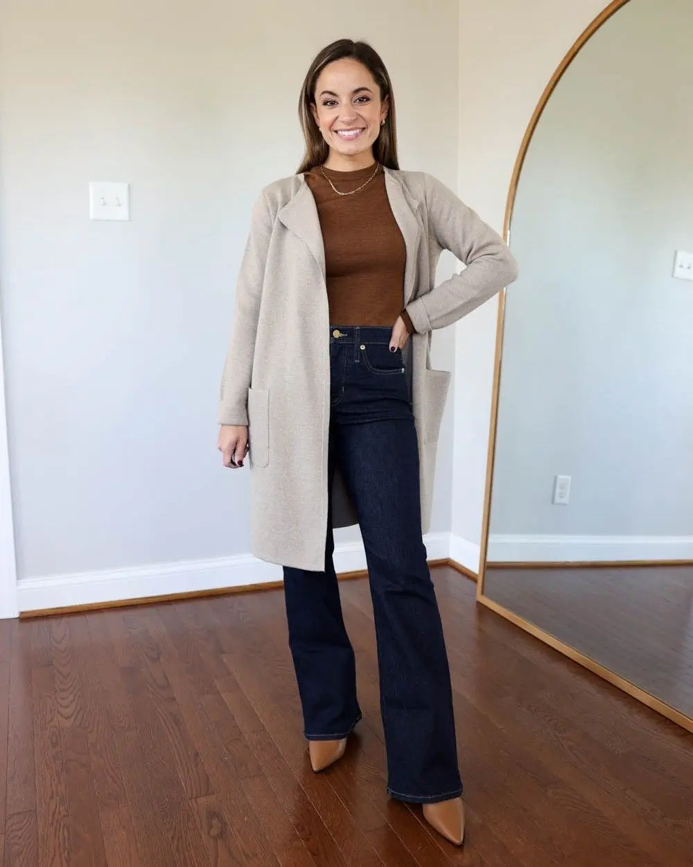 Look feminino com cardigã bege, blusa marrom e jeans flare escuro, estilo casual elegante.