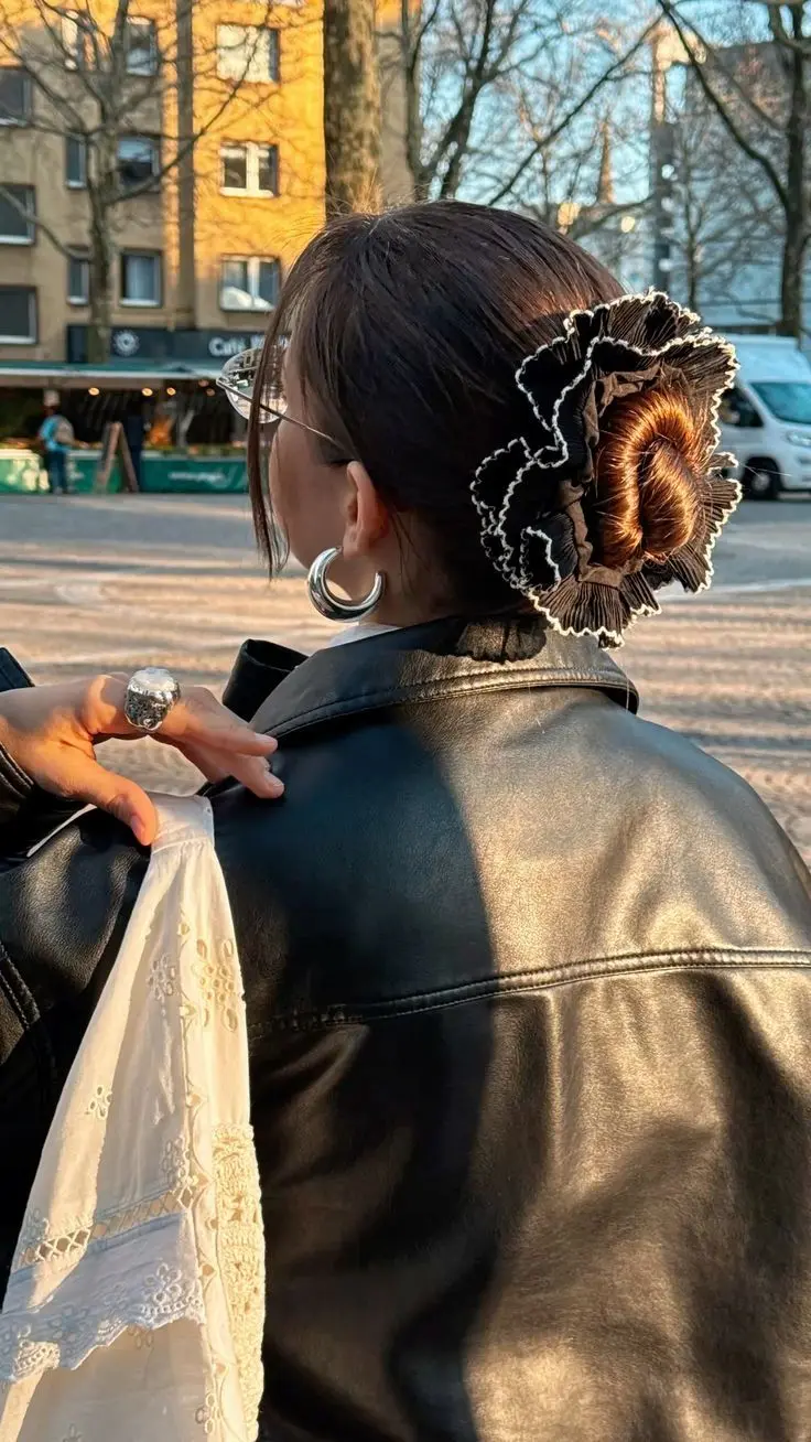 Coque baixo com scrunchie de seda, acessório elegante e discreto.