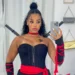 Fantasias DIY: 6 ideias simples para o Halloween 2025 que você pode fazer em casa 12 Mulher com fantasia de ninja, com vestido preto, fita vermelha e acessórios, posando para foto.