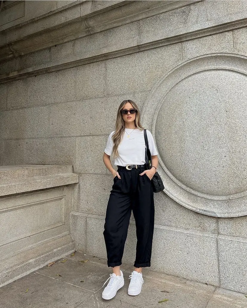 Mulher usando pantacourt preta de malha leve com tênis brancos.