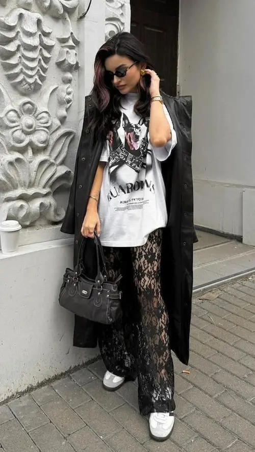 Look moderno com renda e sobretudo preto, misturando leveza e sofisticação.