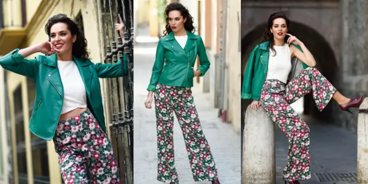 Mulher usando uma calça estampada florida e jaqueta verde em cenário urbano na primavera de 2025, destacando um look moderno e elegante.