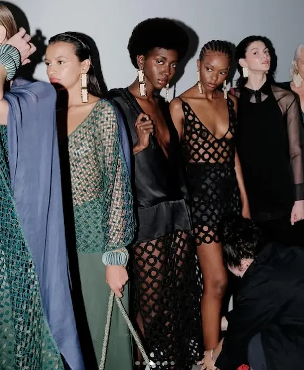 Modelos desfilando com roupas artesanais e de design exclusivo, em um evento de moda, com destaque para as marcas que valorizam o trabalho artesanal como Catarina Mina.