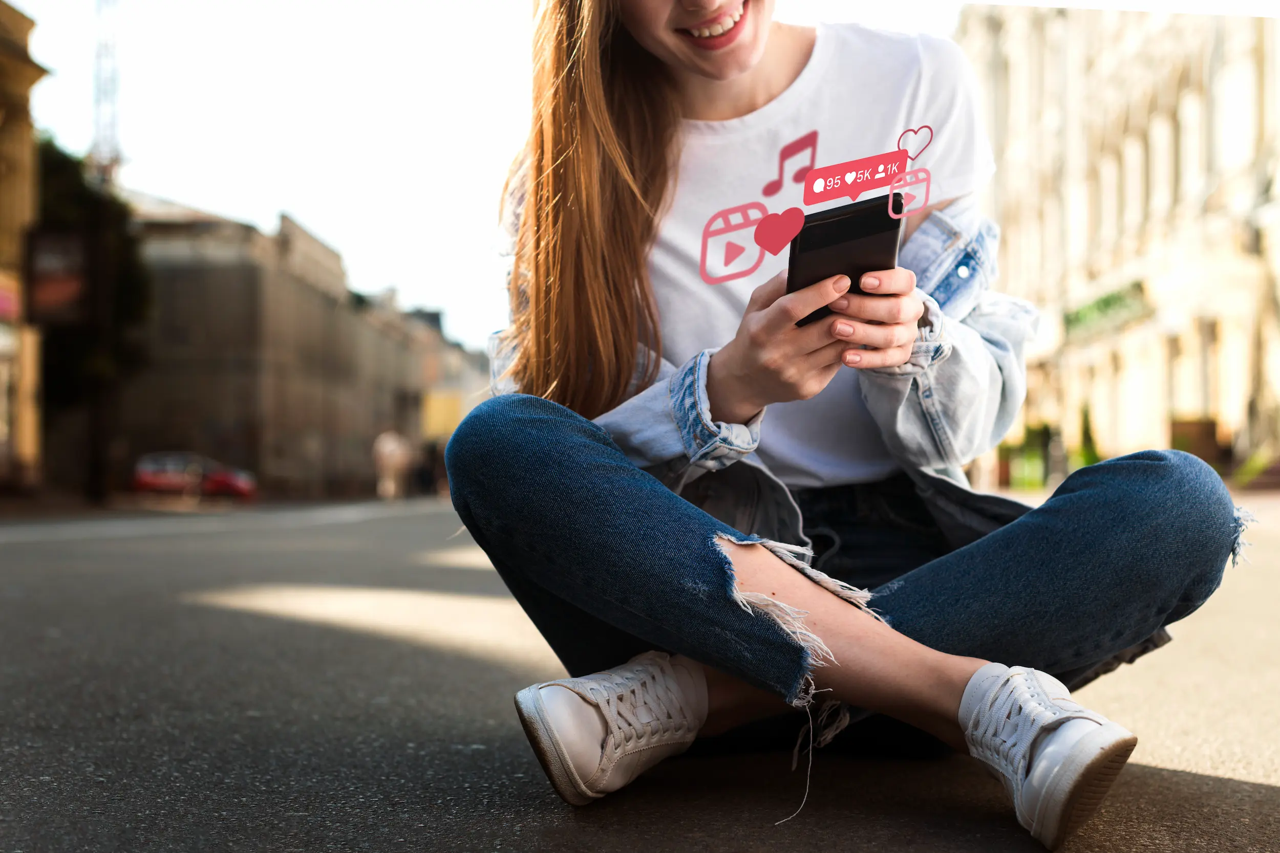 Pessoa sorrindo e interagindo com o celular, mostrando ícones de redes sociais e curtidas, transmitindo boas vibrações e alegria.