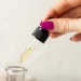 Conta-gotas com óleo de semente de uva sendo aplicado para hidratação da pele e dos cabelos.