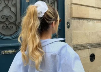 Testados e aprovados: penteados simples e práticos para você usar em dias quentes 14 Penteado prático para dias quentes, com cabelo preso em um rabo de cavalo alto e preso por um scrunchie branco.