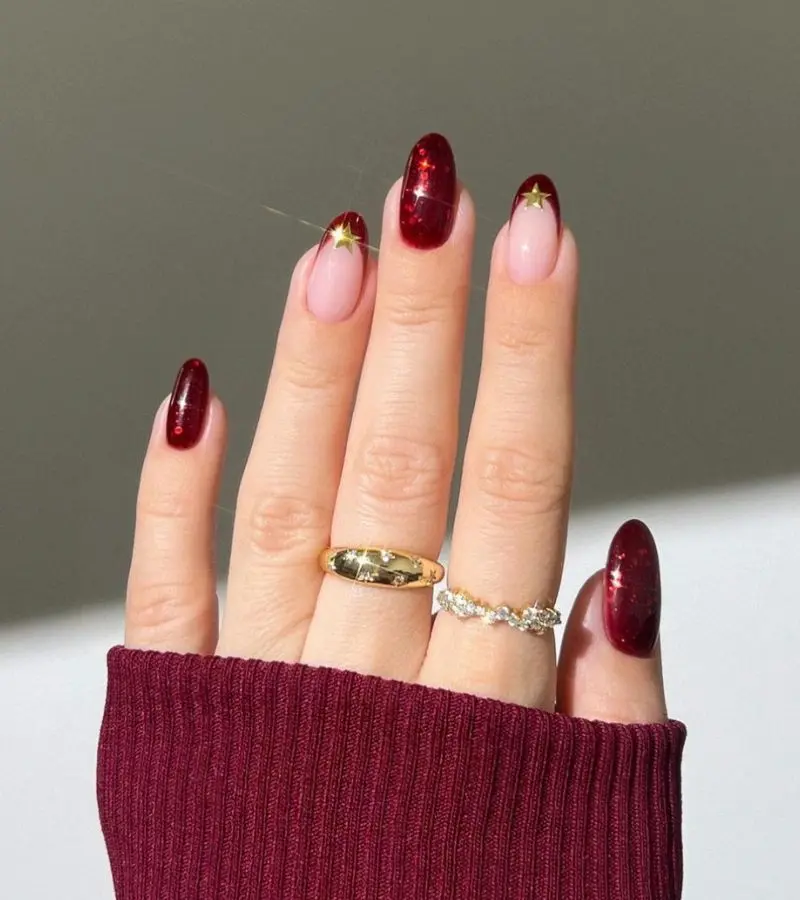 6 inspirações de nail art sofisticadas para o Natal e Ano Novo 6 Unhas decoradas em vermelho com estrelas douradas e acabamento brilhante.