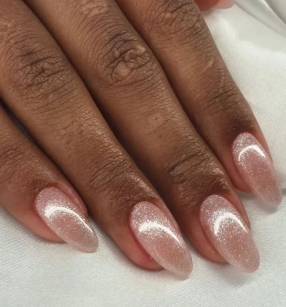 Unhas com acabamento brilhante em tom rosado, criando um visual elegante e delicado.